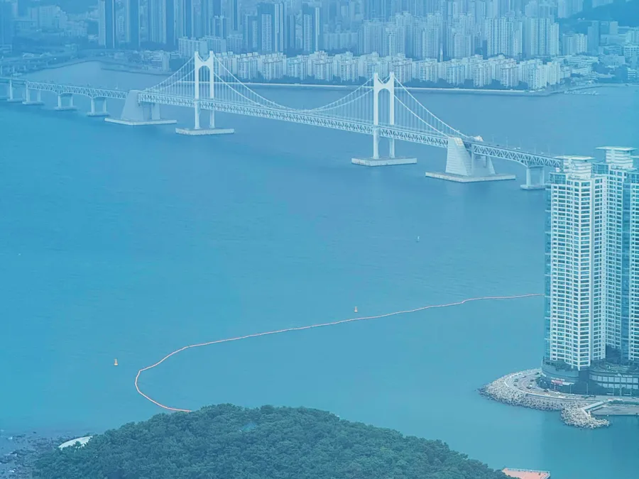 Aerial view of Gwangan Bridge crossing the bay to Busan's Haeundae skyline