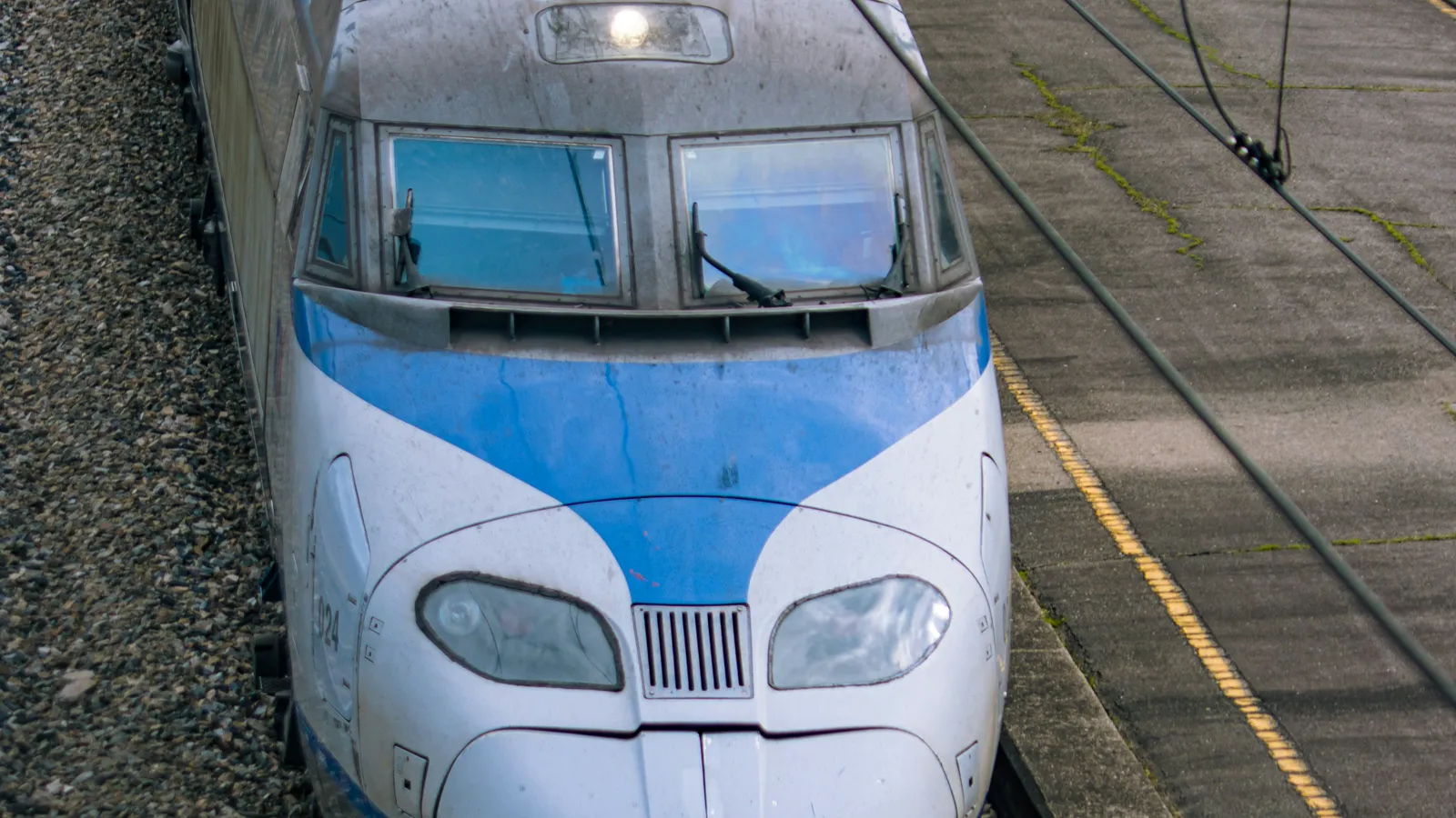 Top-down view of a blue-and-white KTX train's nose standing at a station platform
